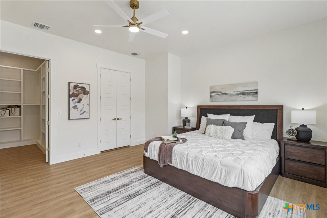 858 Rutherford Fischer, TX 78623 - Photo 16 of 37 a bedroom with a large bed and a ceiling fan
