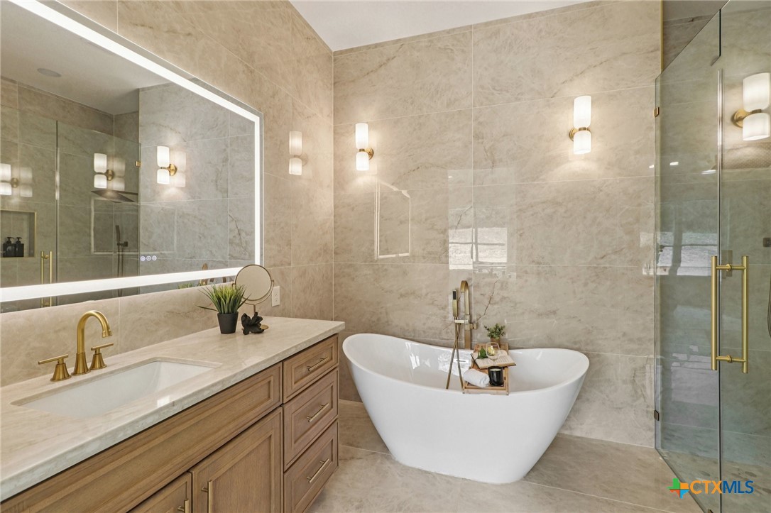 858 Rutherford Fischer, TX 78623 - Photo 18 of 37 a bathroom with a sink a mirror a lamp and bathtub