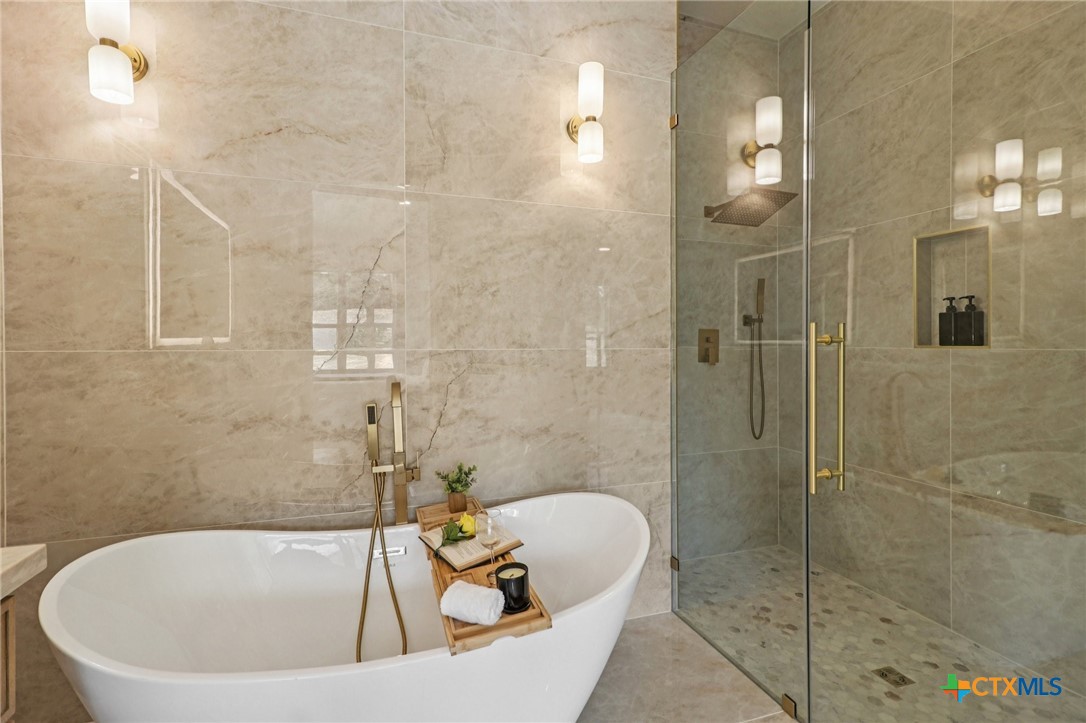 858 Rutherford Fischer, TX 78623 - Photo 19 of 37 a white bath tub sitting in a bathroom and a shower