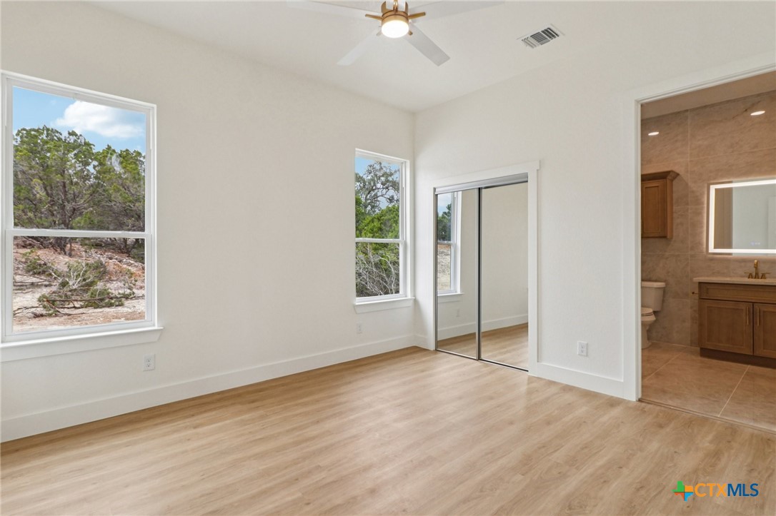 858 Rutherford Fischer, TX 78623 - Photo 25 of 37 a view of an empty room with a window and wooden floor