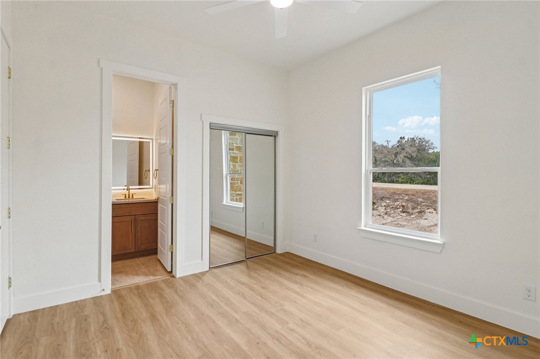 858 Rutherford Fischer, TX 78623 - Photo 27 of 37 a view of a bedroom with wooden floor and a window