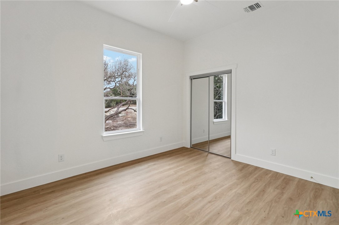 858 Rutherford Fischer, TX 78623 - Photo 29 of 37 an empty room with wooden floor and windows