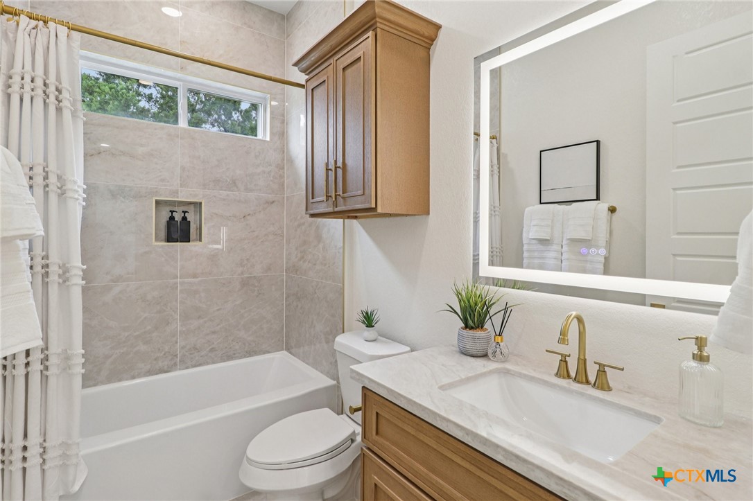 858 Rutherford Fischer, TX 78623 - Photo 30 of 37 a bathroom with a granite countertop sink a toilet and bathtub