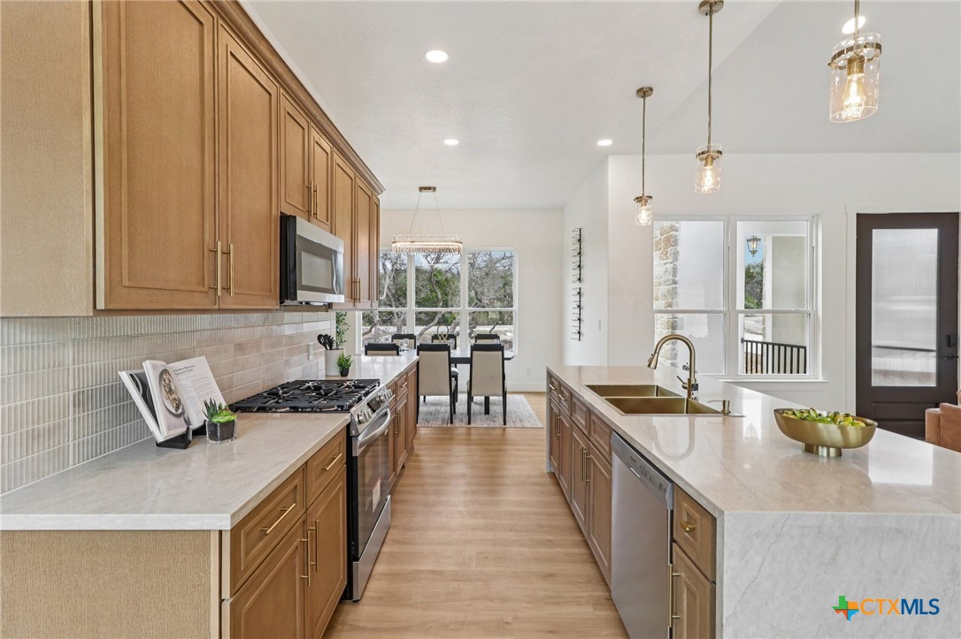 858 Rutherford Fischer, TX 78623 - Photo 6 of 37 a kitchen with stainless steel appliances granite countertop a sink a stove oven a counter space and cabinets