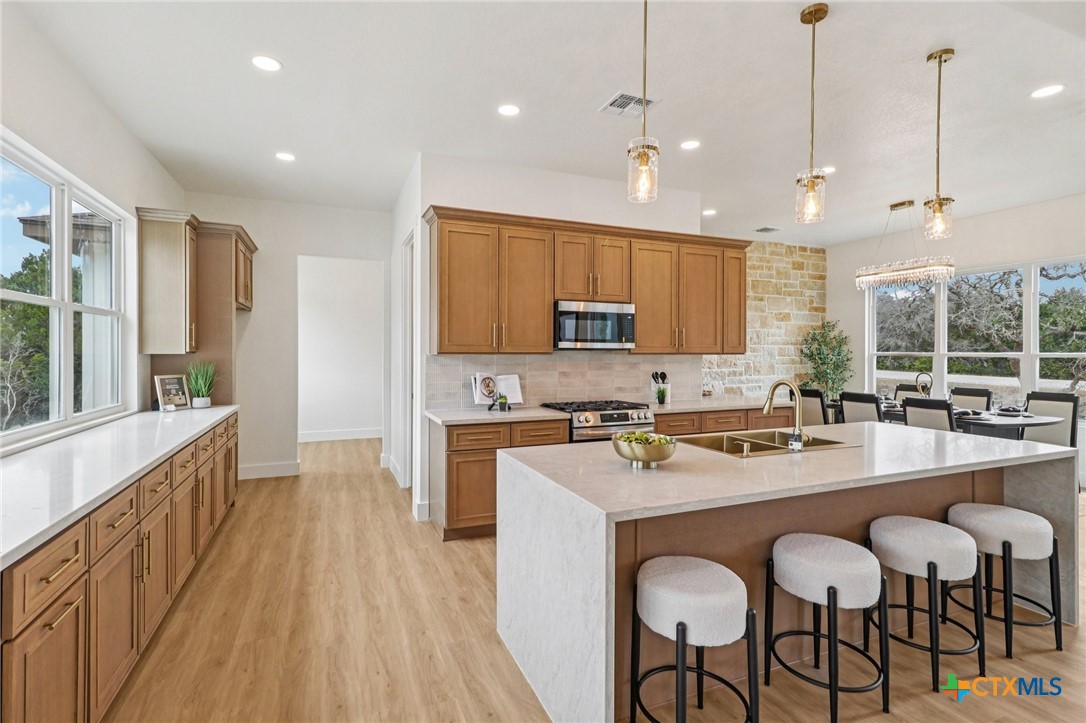 858 Rutherford Fischer, TX 78623 - Photo 8 of 37 a large kitchen with sink a refrigerator and chairs