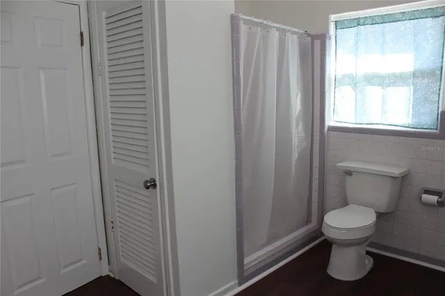 a bathroom with a toilet and a shower curtain