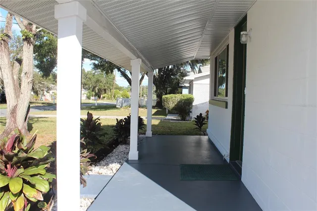 a view of a porch with chairs and potted plants