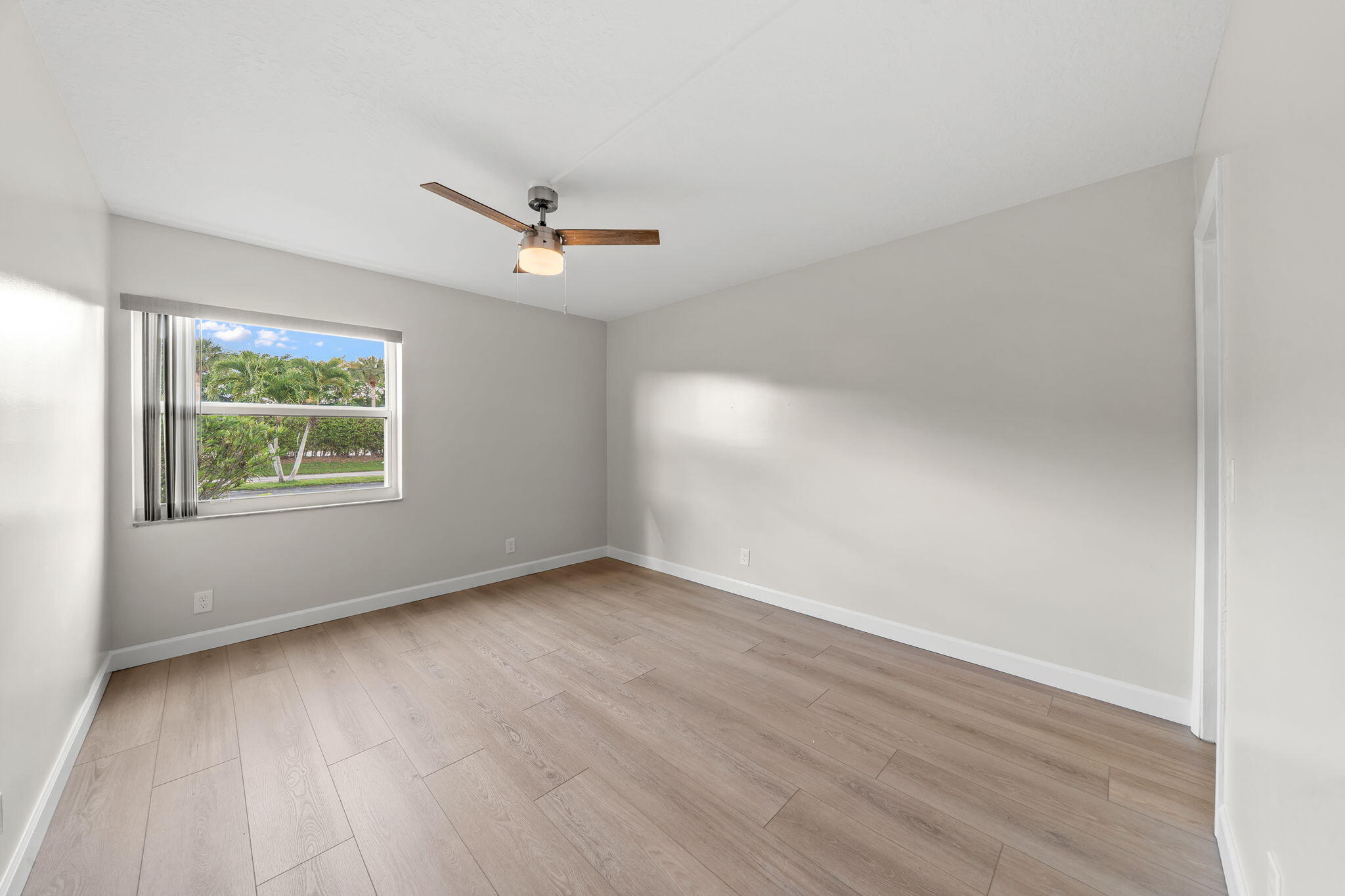 932 Flanders T Delray Beach, FL 33484 - Photo 15 of 28 an empty room with wooden floor and windows
