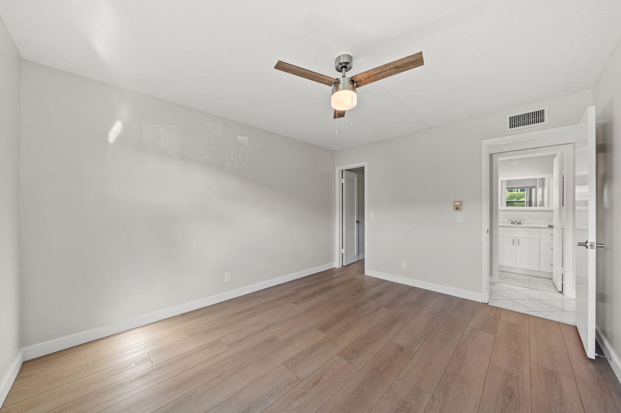 932 Flanders T Delray Beach, FL 33484 - Photo 16 of 28 an empty room with wooden floor and a ceiling fan