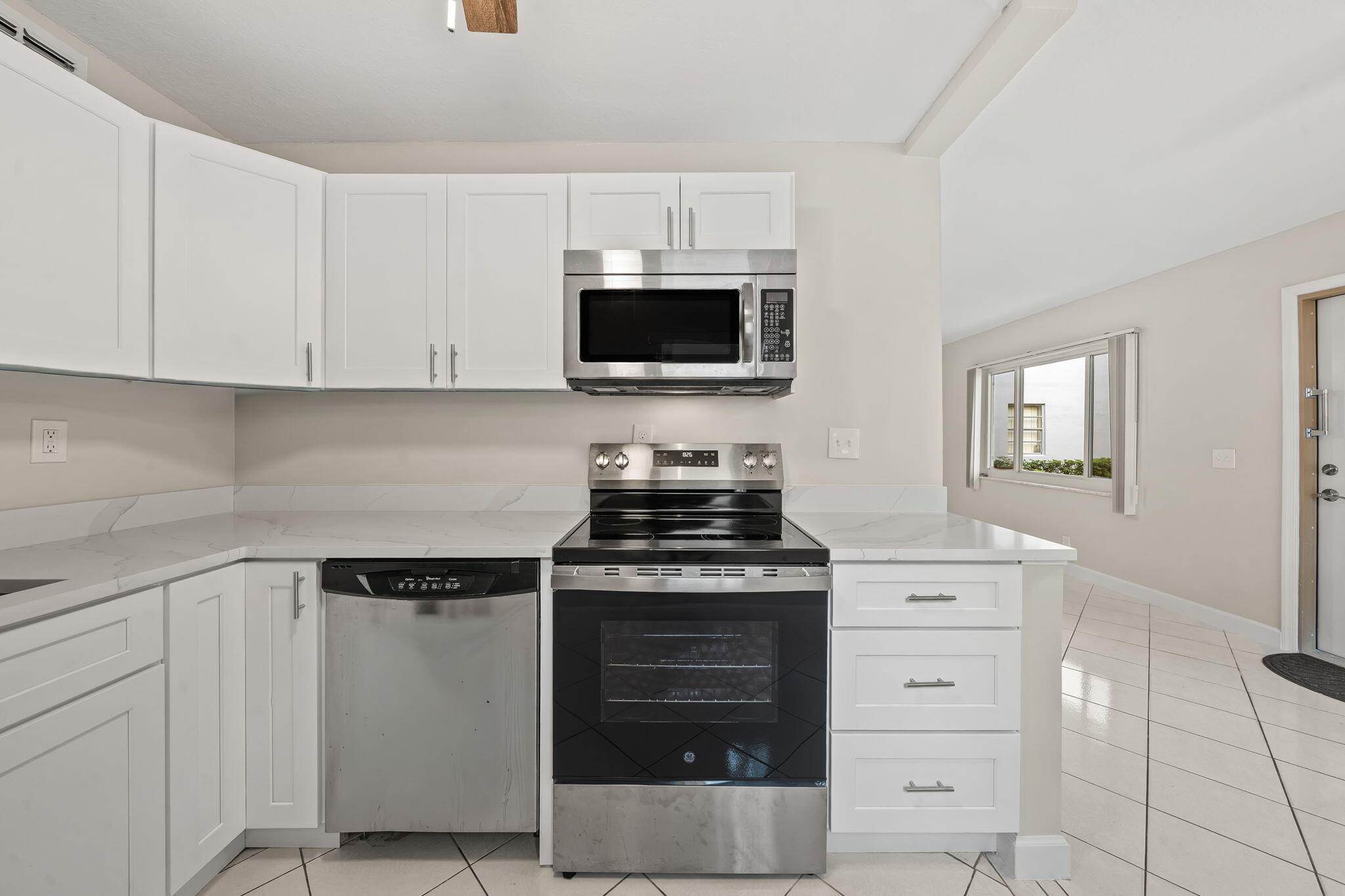 932 Flanders T Delray Beach, FL 33484 - Photo 8 of 28 a kitchen with white cabinets and black appliances