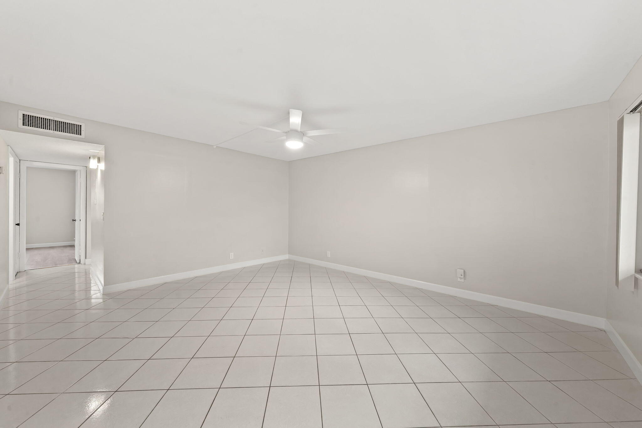 932 Flanders T Delray Beach, FL 33484 - Photo 9 of 28 an empty room with white walls and tiles