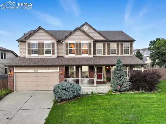 a front view of a house with a garden and plants