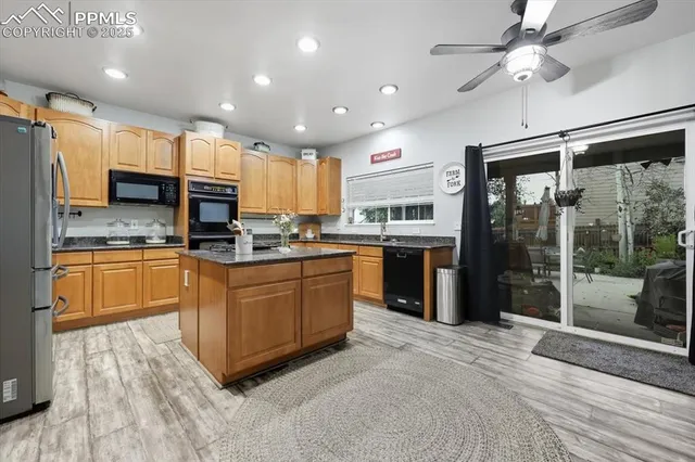 a kitchen with kitchen island granite countertop a sink cabinets and stainless steel appliances