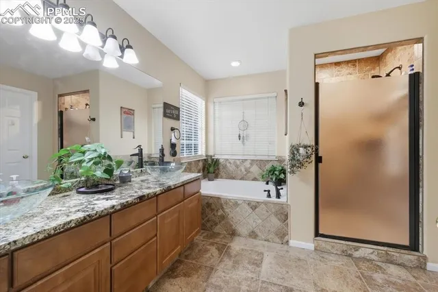 a bathroom with a granite countertop sink a mirror and a shower