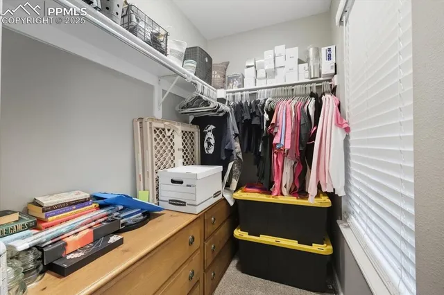 a view of walk in closet with clothes and shoes