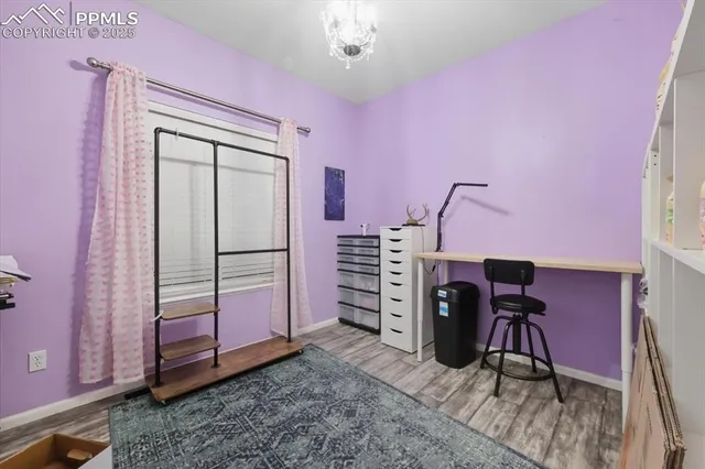 a view of a workspace with furniture and a window