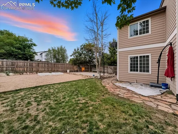 a view of backyard with wooden fence