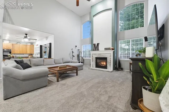 a living room with furniture a large window and a fireplace