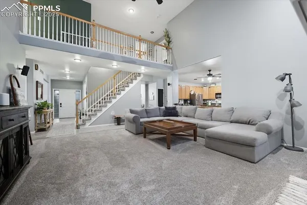 a living room with furniture and a ceiling fan