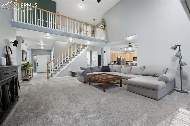 a living room with furniture and a ceiling fan
