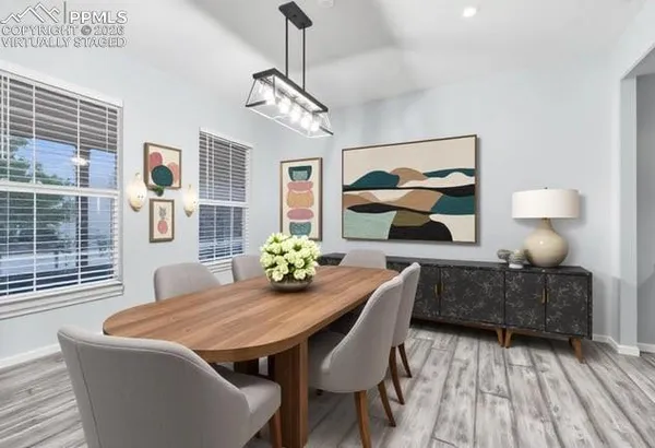 a view of a dining room with furniture a chandelier and wooden floor