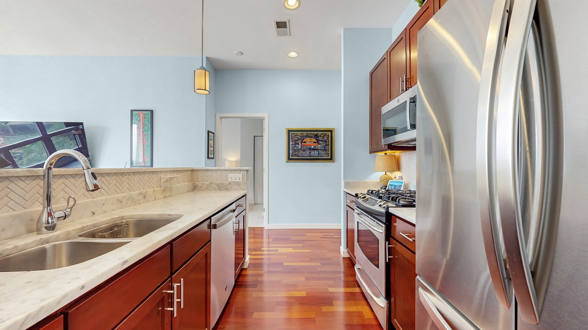 3920 North Sheridan Road, Unit 411 Chicago, IL 60613 - Photo 8 of 28 a kitchen with granite countertop a refrigerator and a sink