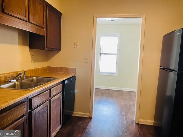 a kitchen with a sink cabinets and wooden floor