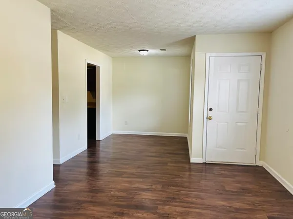 a view of an empty room with wooden floor