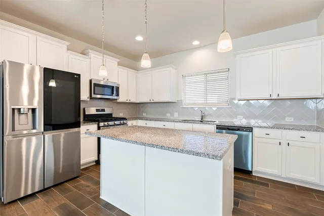 a view of an empty room with a kitchen