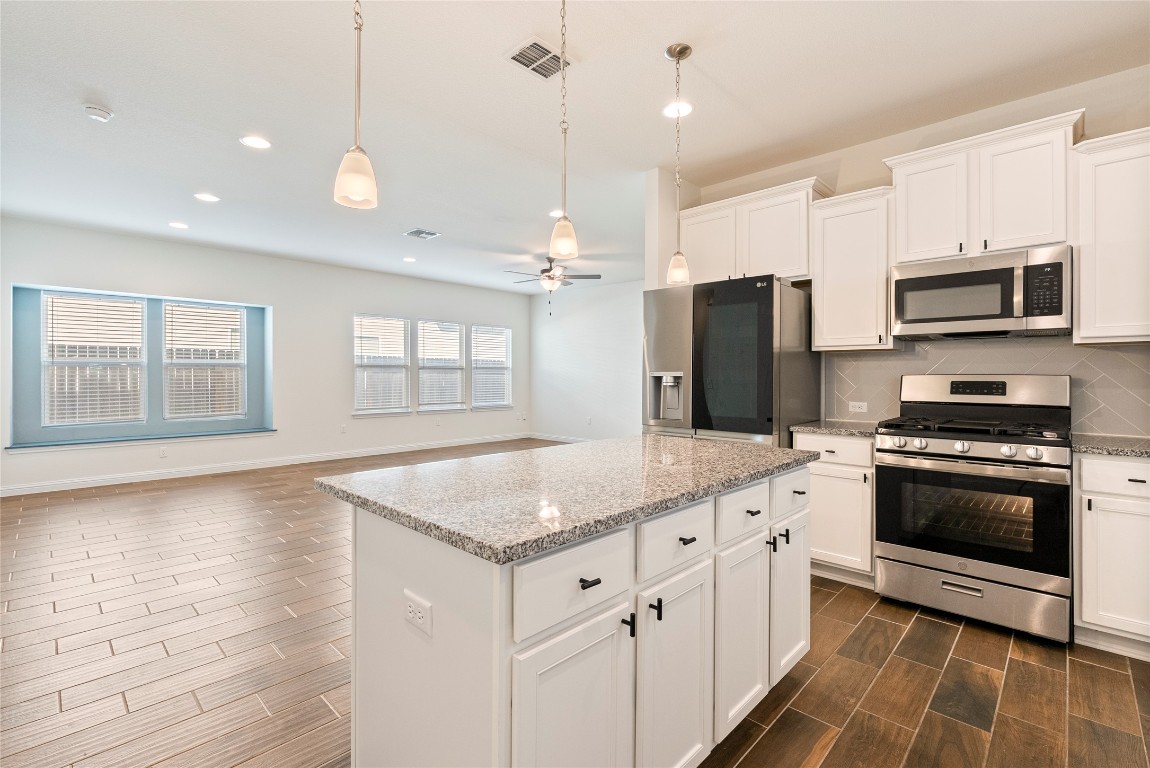 10708 Blacket Drive Austin, TX 78747 - Photo 7 of 20 a kitchen with stainless steel appliances granite countertop a stove a sink and a refrigerator