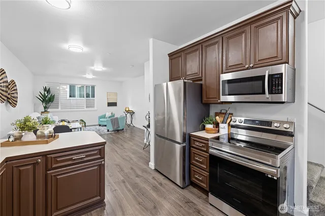 a kitchen with granite countertop a sink stove and refrigerator