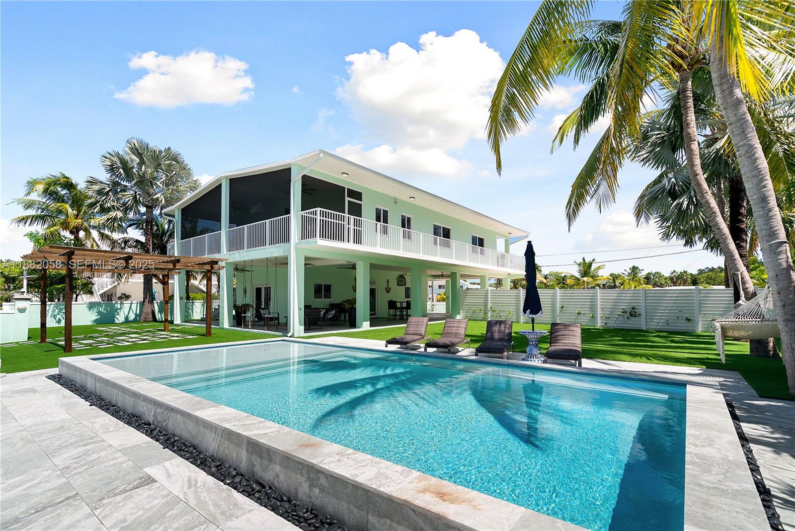 889 Ellen Drive Key Largo, FL 33037 - Photo 3 of 57 a view of a swimming pool with a garden and plants
