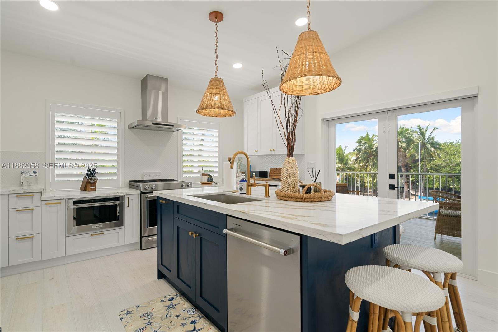 889 Ellen Drive Key Largo, FL 33037 - Photo 6 of 57 a kitchen with kitchen island granite countertop a sink a stove a oven a dining table and chairs with wooden floor