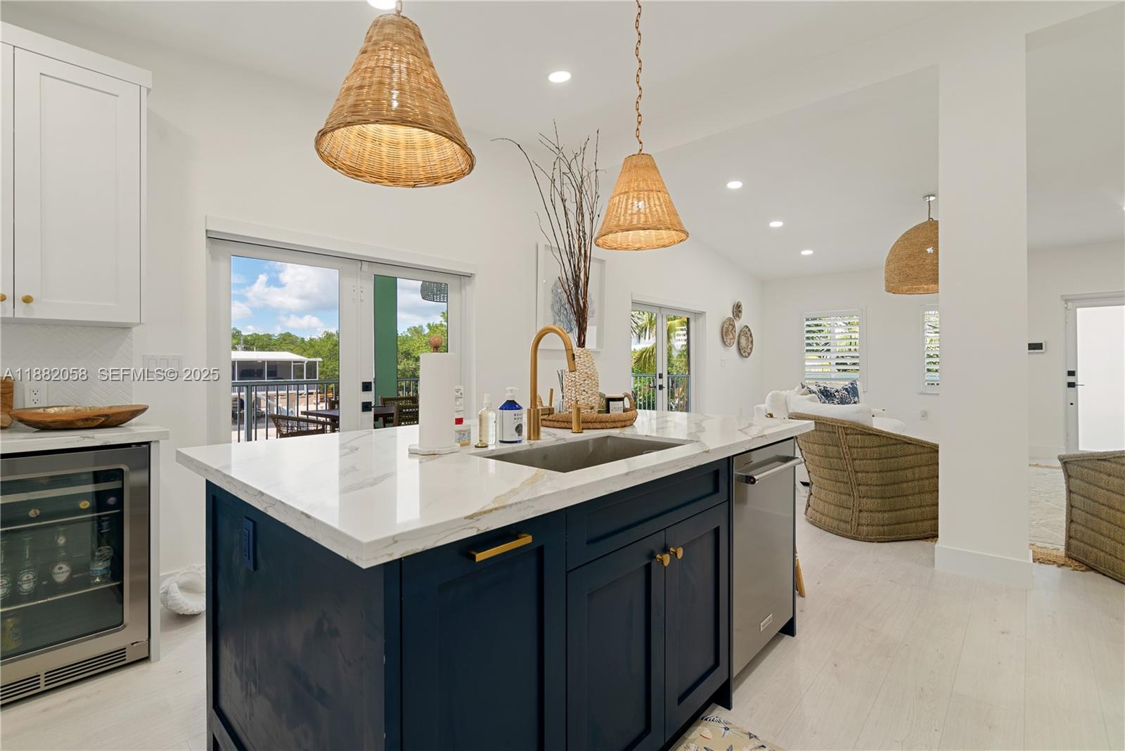 889 Ellen Drive Key Largo, FL 33037 - Photo 7 of 57 a kitchen with a sink dishwasher a stove and a dining table with wooden floor