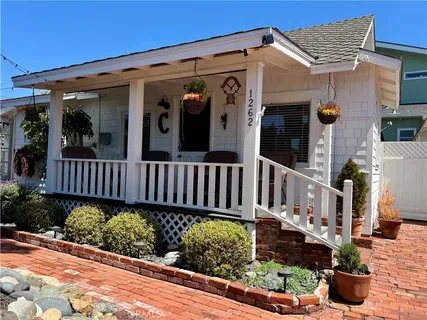a view of a small house with potted plants