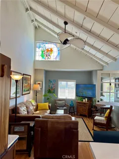 a kitchen with stainless steel appliances granite countertop a stove top oven a refrigerator a dining table and chairs with wooden floor