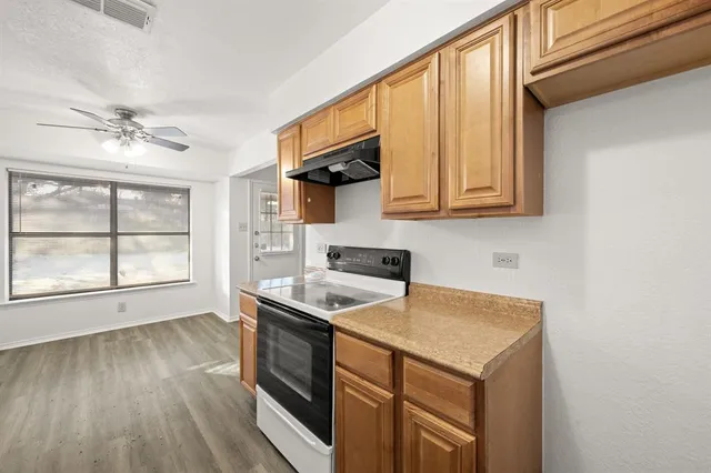 a kitchen with stainless steel appliances granite countertop a stove a sink and a microwave