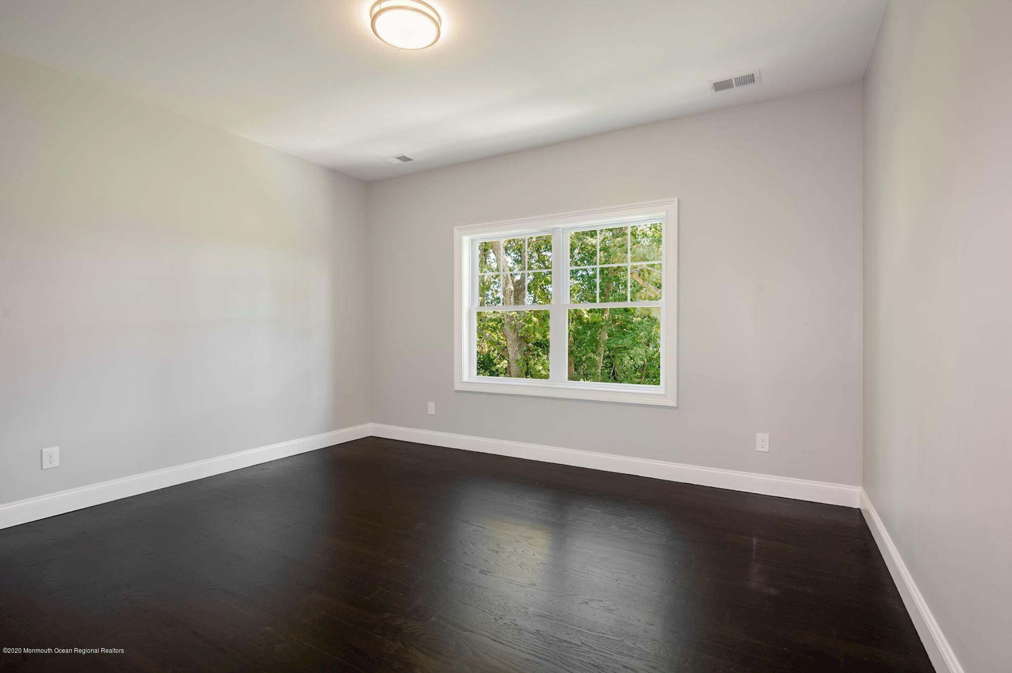 409 Jackson Mills Road Freehold, NJ 07728 - Photo 28 of 35 an empty room with wooden floor and windows