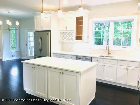 409 Jackson Mills Road Freehold, NJ 07728 - Photo 10 of 35 a kitchen that has a sink a window and a wooden floor