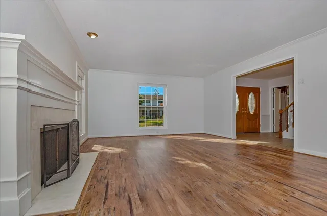 wooden floor fireplace and windows in an empty room