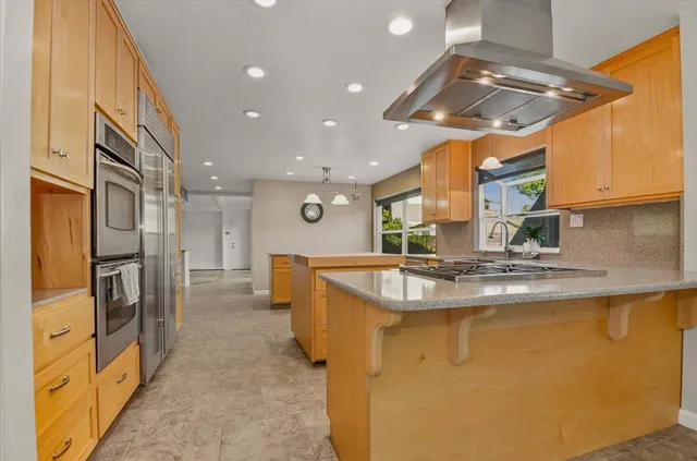 a kitchen with stainless steel appliances granite countertop a stove and a refrigerator