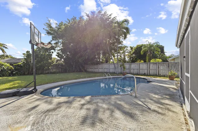 a view of backyard with swimming pool and sitting area
