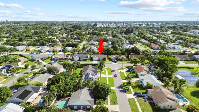 an aerial view of residential houses with outdoor space and trees