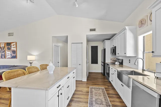 a large white kitchen with stainless steel appliances lots of counter top space
