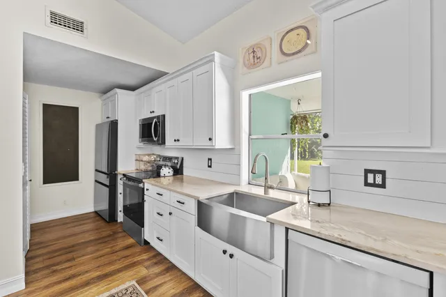 a kitchen with a sink dishwasher a stove and a refrigerator with wooden floor
