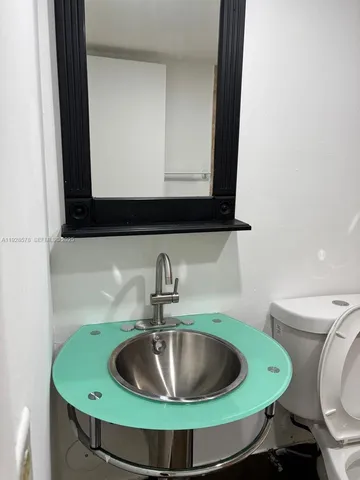 a bathroom with a toilet sink and mirror