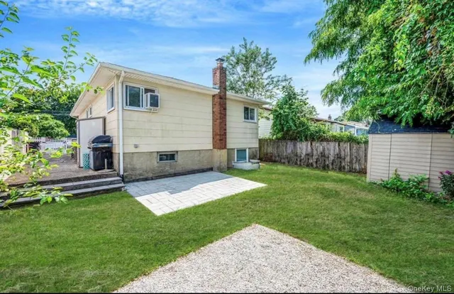 a view of backyard with table and chairs and wooden fence