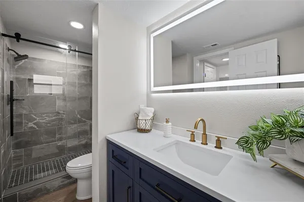 a bathroom with a sink a toilet and shower