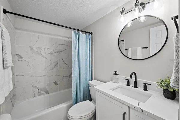 a bathroom with a sink a mirror a toilet and a bathtub