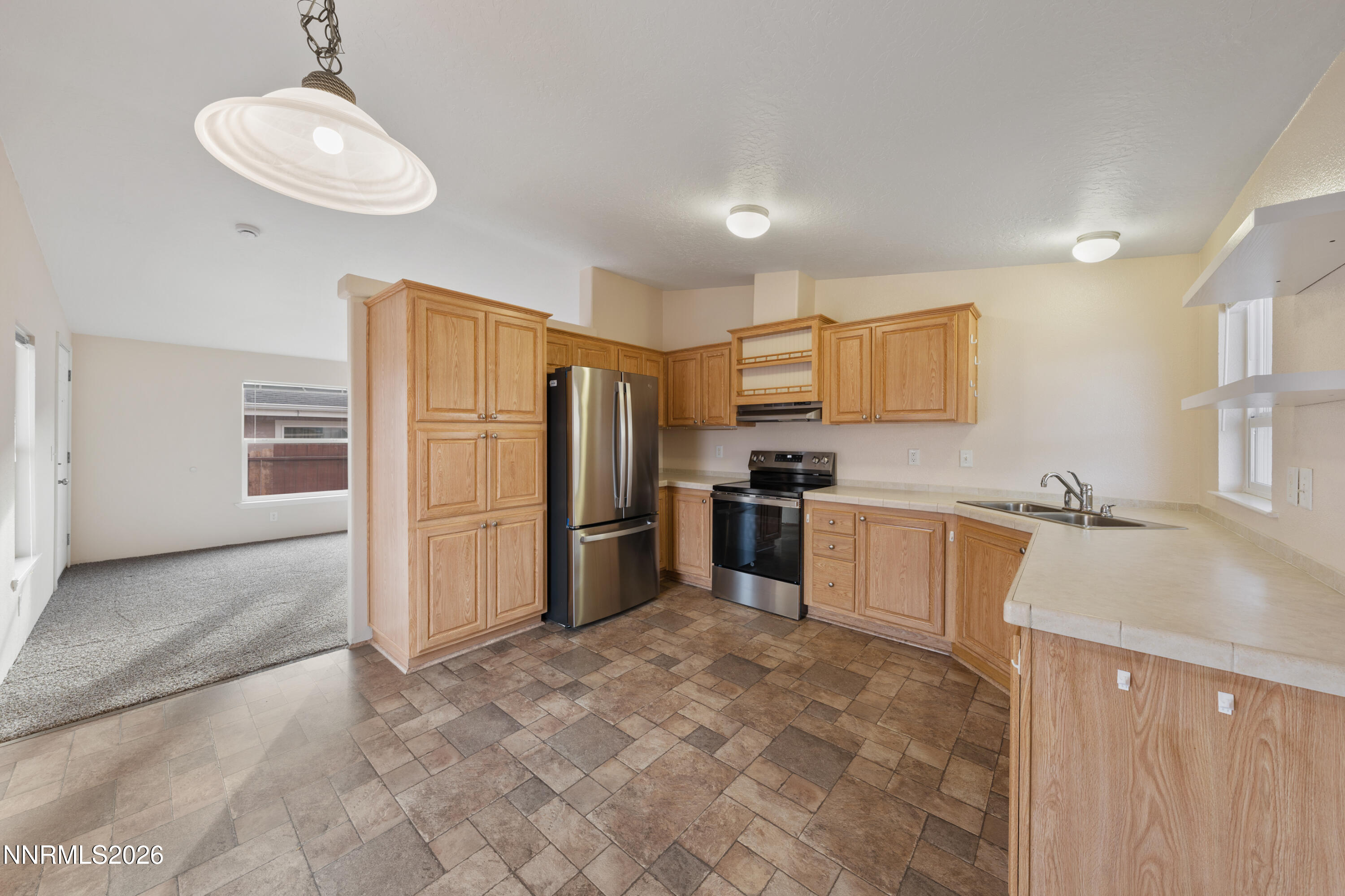 5277 Mt Dana Drive Reno, NV 89506 - Photo 10 of 49 a kitchen with granite countertop a refrigerator and a sink